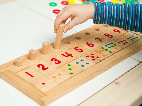 Playful Learning of Math Equivalence: Design, Testing, and Analysis of a Game with Children and Caregivers
