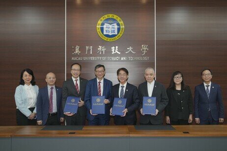 Representatives from both universities take photos at the signing ceremony