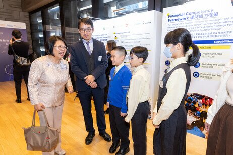 At the launch ceremony of the Hong Kong Jockey Club Financial Education Programme, Professor Christina Yu Wai-mui (left) from the Department of Social Sciences and Policy Studies at EdUHK, speaks with participating students and principal 