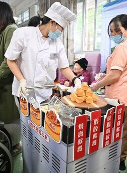 Student volunteers from EdUHK dressed up as chefs, use a traditional cart to serve Wuyi hometown dim sum